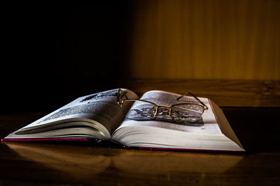 Close-up of eyeglasses over open book on table