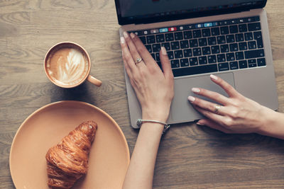 High angle view of woman using laptop on table