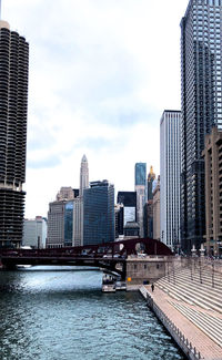 Modern buildings by swimming pool against sky