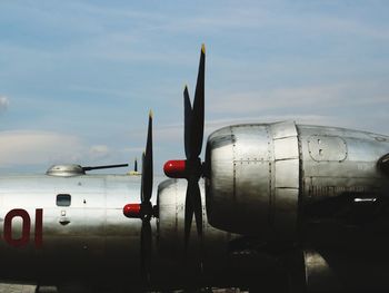 Close-up of airplane at airport runway against sky