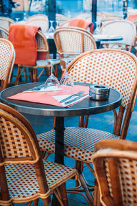 Empty chairs and tables at sidewalk cafe