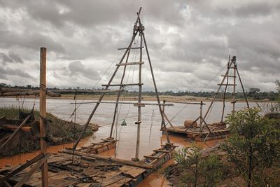 Sailboats on river against sky