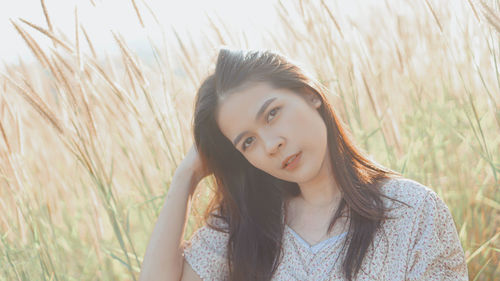 Portrait of beautiful young woman lying on field