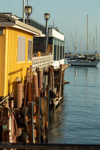 Boats moored at harbor against sky
