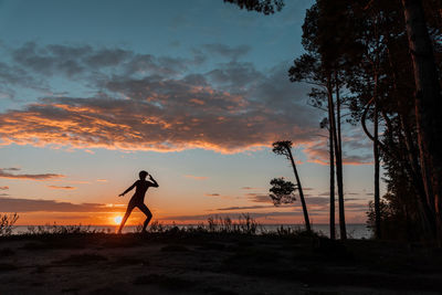 A woman does karate at sunset