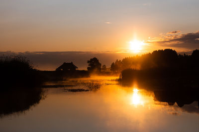 Scenic view of lake against sky during sunset