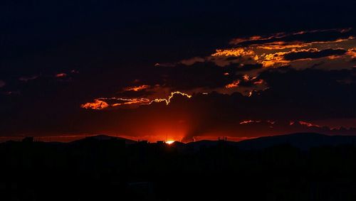 Silhouette landscape against sky at sunset