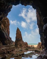 Rock formations by sea against sky