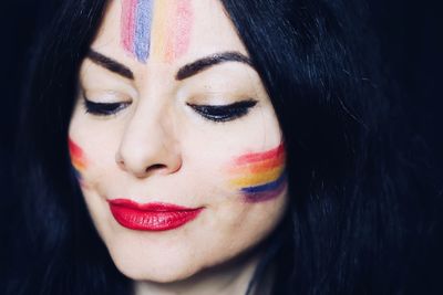 Close-up portrait of a beautiful young woman with rainbow makeup 