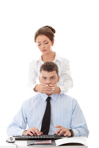 Portrait of young couple sitting against white background
