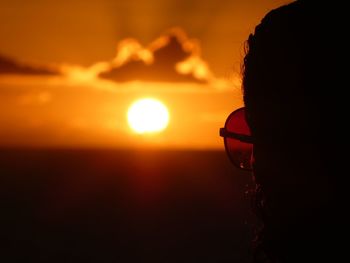 Close-up portrait of silhouette man against orange sky