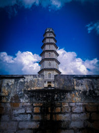 Low angle view of old building against cloudy sky