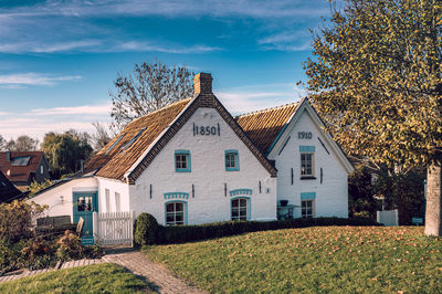 Houses and trees in town against sky