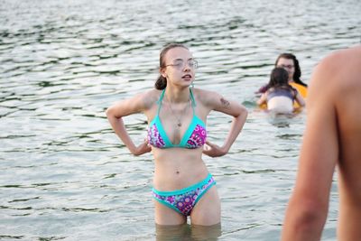 Teenage girl in bikini standing at beach