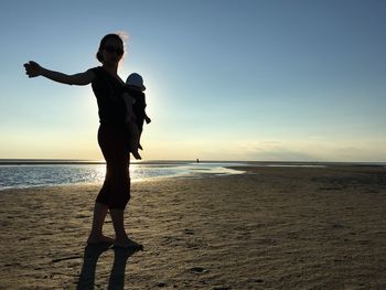 Rear view of woman standing on beach