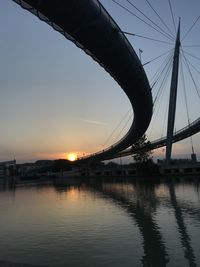 Bridge over river against sky during sunset