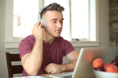 Close-up of man using mobile phone while sitting on table