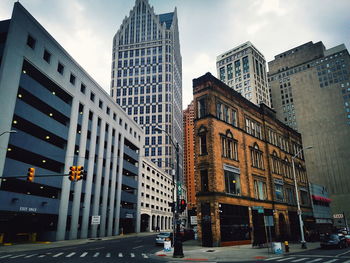 Buildings by road against sky in city