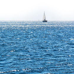 Sailboat sailing in sea against clear sky