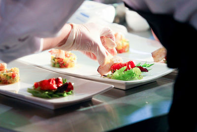 Cropped image of chef styling food in plate
