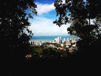 View of cityscape against cloudy sky