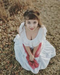 High angle portrait of woman sitting on field