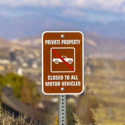 Close-up of road sign against sky