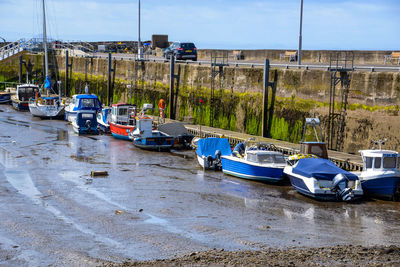 Boats moored on shore against sky