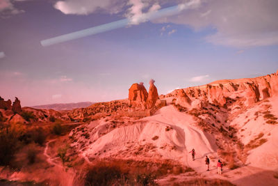 Rock formations on landscape against cloudy sky