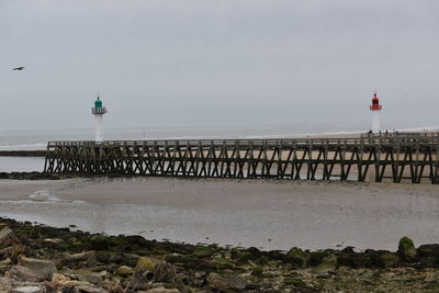 Lighthouse by sea against sky