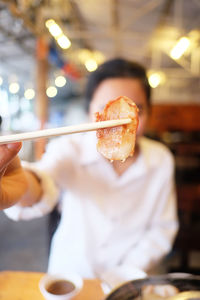 Midsection of man holding ice cream on table in restaurant