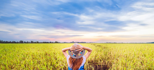 Full length of woman standing on field against sky