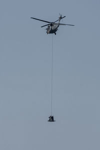 Low angle view of helicopter against clear sky