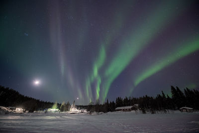 Scenic view of snow covered landscape against sky at night