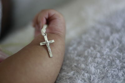 Close-up of human hand on cross