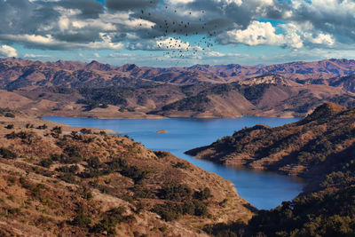 Scenic view of lake by mountains against sky