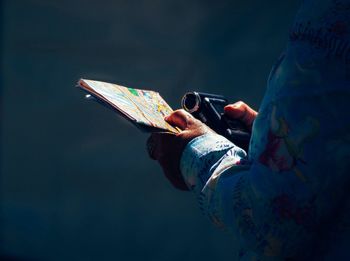 Cropped image of tourist holding map and digital camera