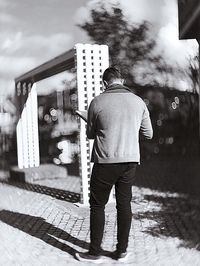 Rear view of man standing against built structure