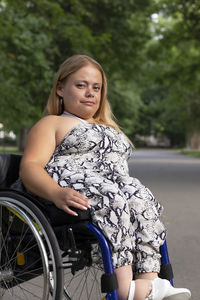 Portrait of young woman sitting on road