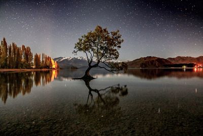 Scenic view of lake against sky at night