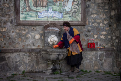 Full length of man standing against wall