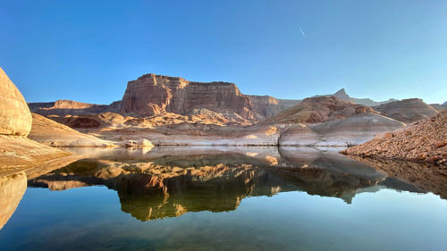 Scenic view of lake and mountains against clear blue sky