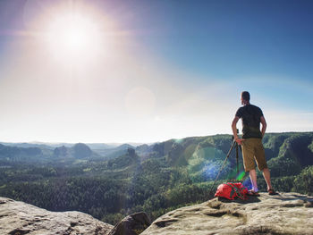 Rear view of man looking at mountains against sky