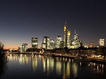 Illuminated buildings in city against sky at night