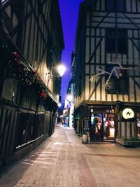 Illuminated street amidst buildings at night