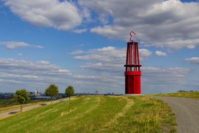 Lighthouse on field against sky