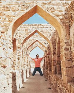 Full length of man jumping at walking in historic building