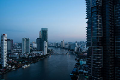 River amidst buildings in city against sky