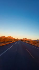 Road against clear blue sky