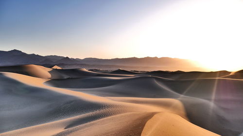 Scenic view of desert against sky during sunset